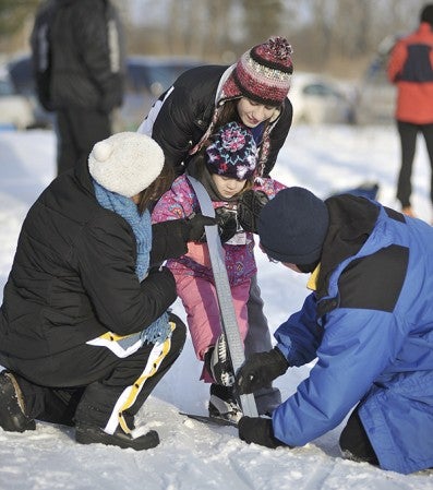Steve Williams waxes the skis of his granddaughter, Madeline Schoenstedt, 3, while she gets some help from grandma Bonnie Williams and aunt Katie Williams during the beginners/kids race in 2011. 