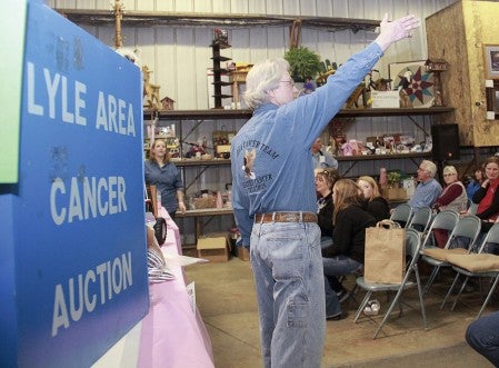 Al Smith points out a bid during the auction Friday night.