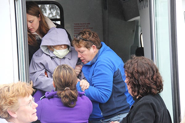 Alyssa Picht, behind, Donna Hovey, right, and Nicole Wahl, front, assist 100-year-old Margaret Godfrey down the steps of a bus Thursday morning in Kensett, Iowa. The women worked for Lutheran Retirement Home in Northwood, Iowa, which had been evacuated because of an explosion at a fertilizer storage facility at the municipal airport. -- Tim Engstrom/newsroom@austindailyherald.com