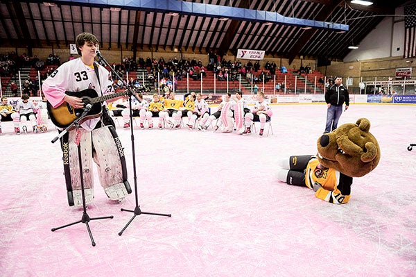 Bruins goalie Jacob Stack serenades the crowd and Bruiser during a jersey auction Saturday night following the annual Paint the Rink Pink game at Riverside Arena. Photo -- Eric Johnson