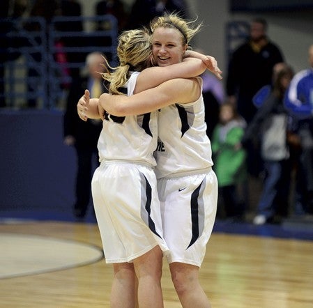 Blooming Prairie's Kalyn Naatz, right, hugs her teammate Sara Noble after the Awesome Blossoms upset Lyle-Pacelli 72-63 in Mayo Civic Auditorium Monday. -- Rocky Hulne/sports@austindailyherald.com