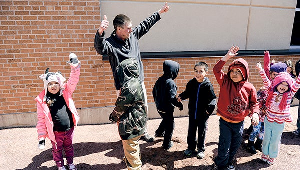 Woodson Kindergarten Center teacher Jason Denzer gets a hands-up consensus from his students after asking if they would like to see a greenhouse come to Woodson earlier this month. Herald file photo