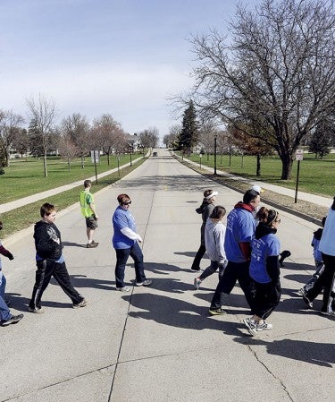 Walkers cross Main Street South during the third annual Stepping Out for Autism Walk Saturday morning. 