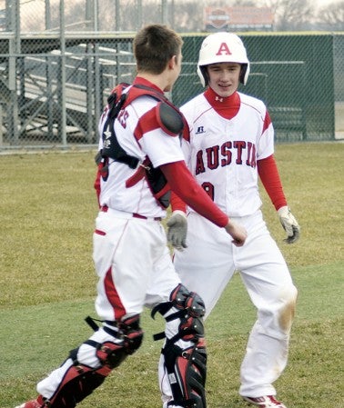 Austin's Nate Conner is congratulated by catcher Dylan Gasner after Conner scored the game-winning run against Winona in Dick Seltz Field Thursday. -- Rocky Hulne/sports@austindailyherald.com