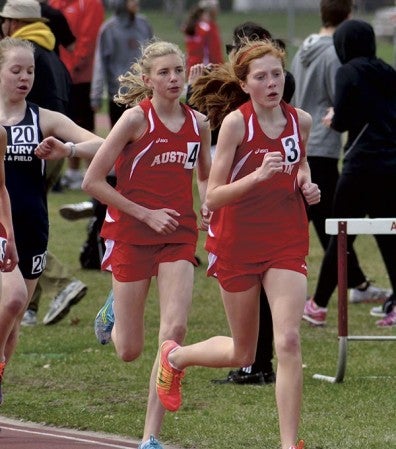 Austin's Paiton Schwab, right, and Abby Lewis, center, run in the 3200-meter run at the Packer Invite at Larry Gilbertson track and field. -- Rocky Hulne/sports@austidailyherald.com