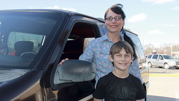 Tammy Lawson and her son, Nathan, stand next to the 1990 Dodge Caravan given to Lawson and her family by Cornerstone Church Saturday. Jason Schoonover/jason.schoonover@austindailyherald.com