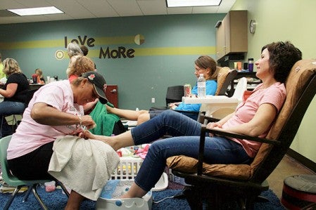 Sharon Hovland, left, gives Kathy Uwing a pedicure Saturday morning at Cornerstone Church in Austin.