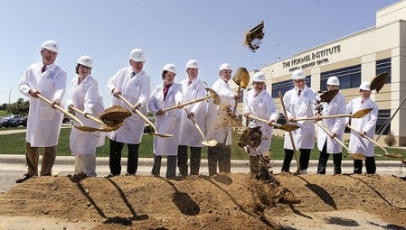 Diginitaries pitch shovel-fulls of dirt as ground is broke for the new Hormel Institute expansion during a ceremony in May. Herald file photo