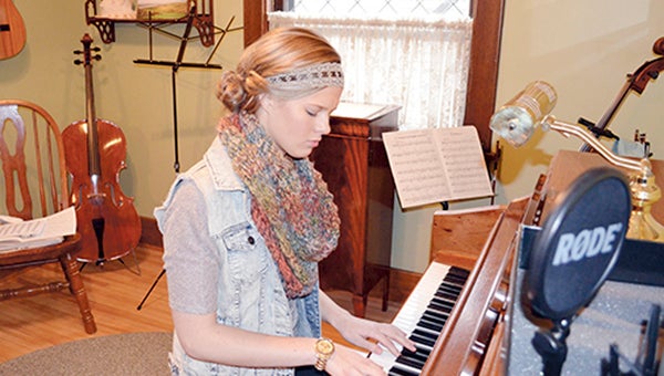 Molly Kate Kestner plays music on her family's piano Monday evening. Kestner has drawn global attention after her song "His Daughter" was seen more than 180,000 times on Youtube since April 20. Trey Mewes/trey.mewes@austindailyherald.com.
