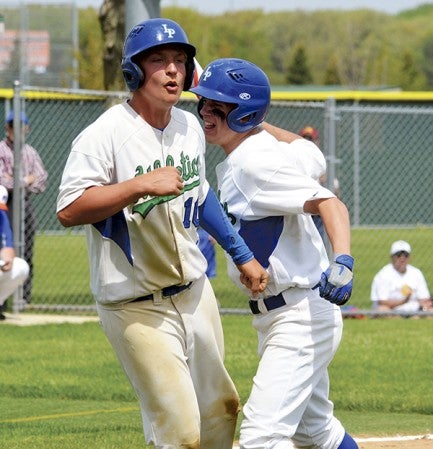 Lyle-Pacelli's Lee Bauer, left and Daniel Bollingberg celebrate a second inning run in the Athletics' 4-3 loss to Randolph in Riverland Saturday. -- Rocky Hulne/sports@austindailyherald.com