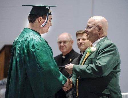 Jacob Herold accepts his diploma from Pacelli President Jim Hamburge during commencement Wednesday night at St. Edwards Catholic Church. 