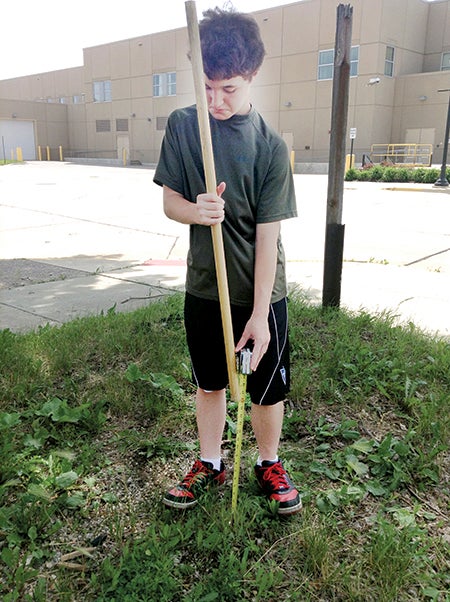Sam Hagen marks out where the memorial will go behind the Austin VFW. Hagen is putting up the memorial as part of his Eagle Scout service project. -- Photo provided