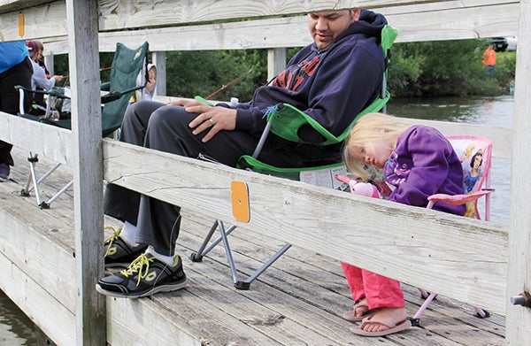 Eric, left, and Samantha Weis, of Oronco, watch the 4-year-old’s fishing line during the Kids Fishing Contest at East Side Lake Park Saturday.  -- Jason Schoonover/jason.schoonover@austindailyherald.com