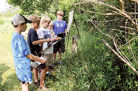 Children taking part in the Jay C. Hormel Nature Center’s Heritage Survival Class kick off the first part of a survival game Thursday. 