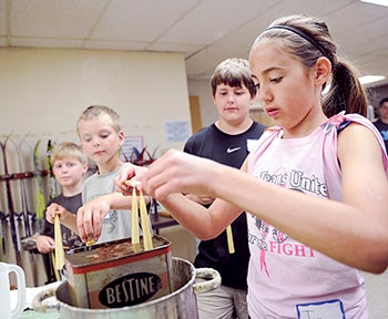 Toria Strampe, 11, dips her candles during candle-making Wednesday. 