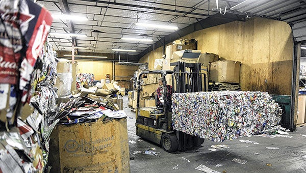 Craig Marshall moves a cube of crushed cans at the Mower County Recycling Center. County officials are looking at switching to single sort recycling which would make recycling easier, but may also cost jobs. Herald file photo