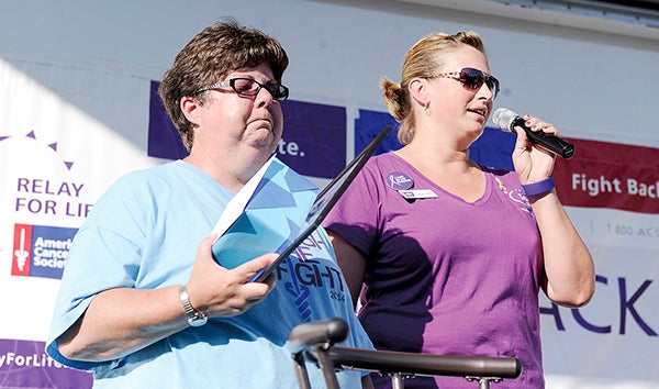 Relay for Life chair Linda Baier, left, tries to compose herself as Sarah Finley announces Baier will be leaving the position Saturday night during the Mower County Relay for Life. -- Photos by Eric Johnson/photodesk@austindailyherald.com