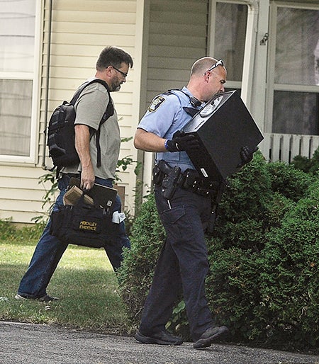 Austin police remove items seized from a home Tuesday afternoon on East Oakland Avenue. -- Eric Johnson/photodesk@austindailyherald.com