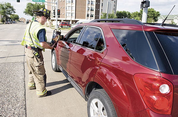 Austin firefighter Tim Hansen takes a donation for the MDA Fill the Boot campaign Thursday afternoon. Firefighters will be out again to wrap up the three-day collection for the Muscular Dystrophy Association today.