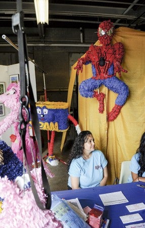 Flor Vargas is surrounded by her pinatas she makes from scratch Saturday at the ArtWorks Festival.