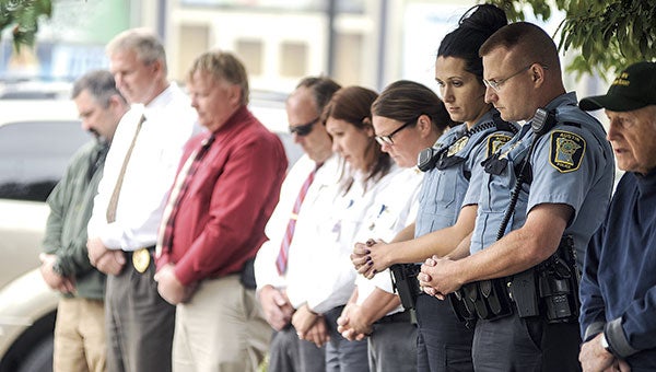 Members of the Austin Police Department, Mower County Sheriff’s Department and Gold Cross Ambulance bow their heads in prayer during the Patriot Day ceremony Thursday. Eric Johnson/photodesk@austindailyherald.com