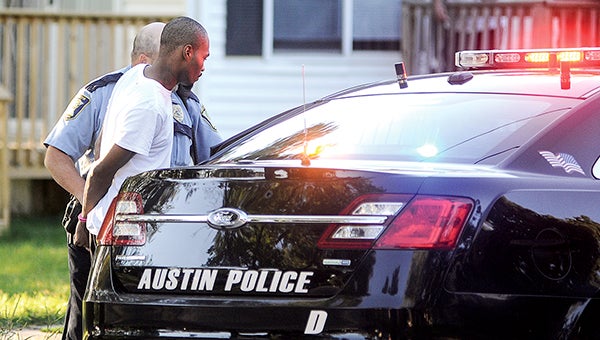 Tyrone Price is placed into the back of a squad car Tuesday night, after being arrested in an alley in the 800 block of Fifth Street Northeast in connection to the shooting in southeast Austin. -- Photos by Eric Johnson/photodesk@austindailyherald.com