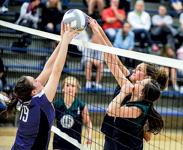 Grand Meadow's Allison Gehling, left, battles at the net with Lyle-Pacelli's Sarah Holtz and Bethany Strouf during game two of their match Tuesday night in Lyle. Eric Johnson/photodesk@austindailyherald.com
