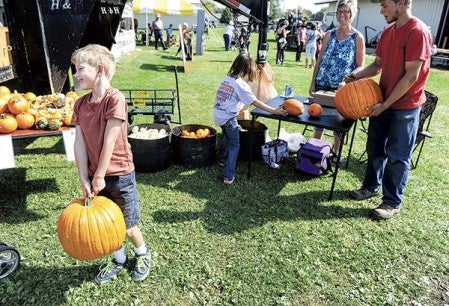 Truman Seals, 7, hefts a pumpkin before it was purchased.  Photos by Eric Johnson/photodesk@austindailyherald.com