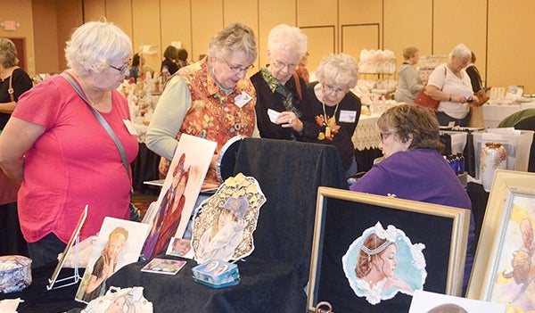 Marci Blattenberger talked about the different peices she has set up Thursday evening at the “Petals and Wings,” the World Organization of China Painters Midwest Porcelain Art Show at the Holiday Inn Conference Center. -- Jenae Hackensmith/jenae.hackensmith@austindailyherald.com