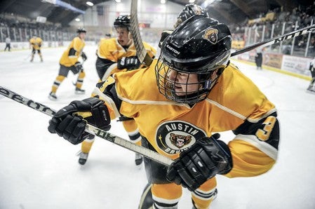 The Austin Bruins' Ian Scheid is pressed up against the boards during the first period against Bismarck this season at Riverside Arena. Herald File Photo