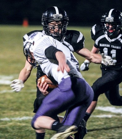 Blooming Prairie's Sam Swenson moves in to tackle Goodhue's Jacob Pasch during the second quarter Saturday night in the Section 1A semifinals in Blooming Prairie. Eric Johnson/photodesk@austindailyherald.com