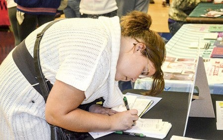  Junior Jessica Tonkin, 16, from NRHEG High School filled out an application at one of the booths Wednesday afternoon. 