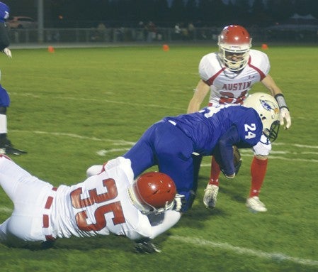 Austin's Brandon Cotter (35) brings down Red Wing's Jakob Meyer in Red Wing Friday. -- Rocky Hulne/sports@austindailyherald.com