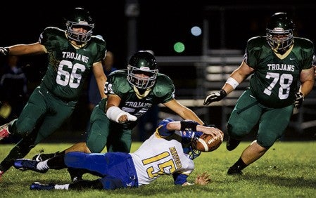 Rushford-Peterson's Kyler Paulson (66), Joshua Agrimson (54) and Conner Johanson (78) swarm Hayfield quarterback Drew Olive (15) as he slips in the backfield on a run during a Southern Football Alliance game Wednesday, Oct. 15, 2014, in Rushford, Minn. -- Andrew Link/Winona Daily News
