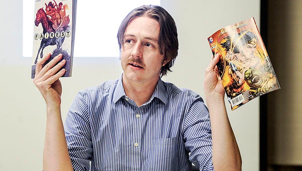 Comic writer Sean E. Williams holds up copies of “Fairest” and “Sensation Comics presents Wonder Woman,” both of which he’s written for. Eric Johnson/photodesk@austindailyherald.com