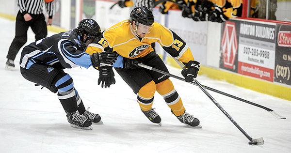 Austin's Trevor Boyd fends off pressure while handling the puck in the second period during the Bruins' New Year's Eve game against Coulee Region. Eric Johnson/photodesk@austindailyherald.com