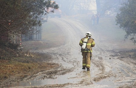 A firefighter walks toward a hog barn fire at 85295 290th Street in rural Freeborn County Monday afternoon. 