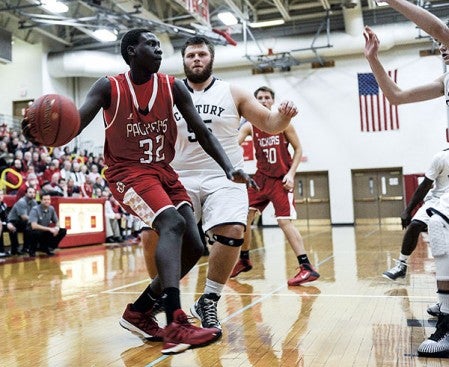 Austin's Oman Oman dumps the ball off the drive during the first half against Rochester Century Friday night in Packer Gym. Eric Johnson/photodesk@austindailyherald.com