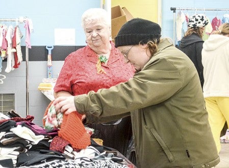 Salvation Army volunteer Bonnie Newell, left, helps Rebecca Culbert choose items at the Salvation Army’s Angel Tree toy donation distribution Friday afternoon at the Salvation Army’s corps building.