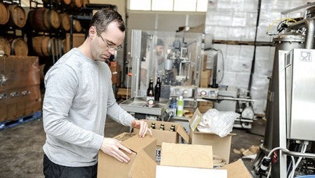 Nick Smith boxes bottles of Four Daughters Vineyard and Winery’s Loon Juice. 