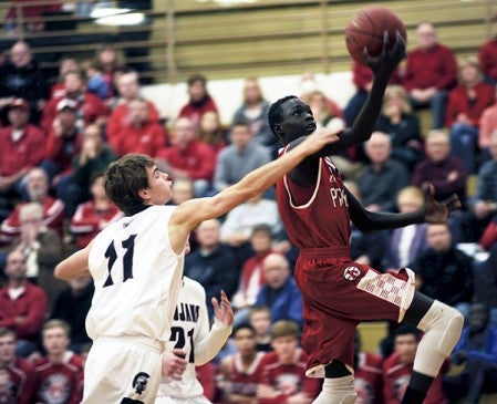Both Gach goes up for a breakaway lay-up as he is fouled by New Prague's Adam Schmitz in Packer Gym Thursday. -- Rocky Hulne/sports@austindailyherald.com