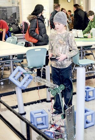 Riley Haugen, 11, practices getting a cube onto one of the posts with his team’s robot Thursday afternoon at I.J. Holton. Riley’s team will compete in the state championship in St. Cloud this weekend.  Jenae Hackensmith/jenae.hackensmith@austindailyherald.com