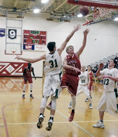Kyle Oberbroeckling shoots over Mayo's Dan Jech in Packer Gym Monday. -- Rocky Hulne/sports@austindailyherald.com
