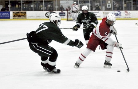 Austin's Kenny Ree handles the puck against Faribault's Koy Payne in Riverside Arena Saturday. -- Rocky Hulne/sports@austindailyherald.com