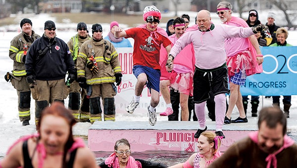 Austin Daily Herald reporter Trey Mewes and County Coordinator Craig Oscarson jump into East Side Lake during the Polar Plunge Saturday afternoon. -- Eric Johnson/photodesk@austindailyherald.com
