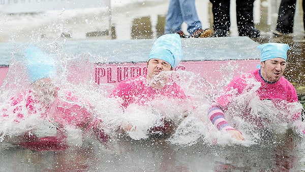 The We Three Things group of William Israel, from left, Ethan Israel and Andrew Sandstrom hit the water during the Polar Plunge Saturday afternoon at East Side Lake. -- Photos by Eric Johnson/photodesk@austindailyherald.com