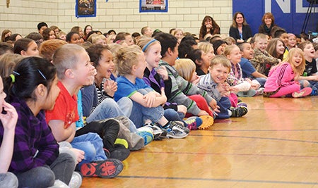 Students at Neveln Elementary School laugh during “Rabbit Tales” on Tuesday afternoon in the Neveln gymnasium. 