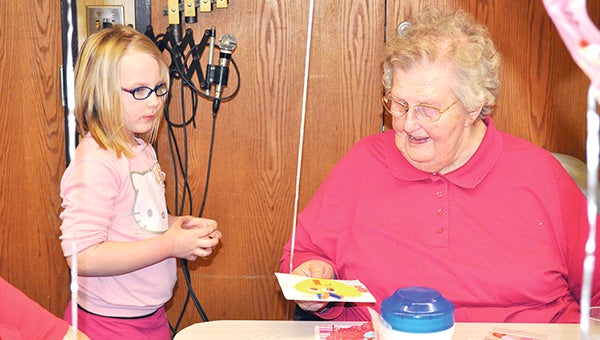 Danica Helle, left, gives a Valentine's Day card to Harriet Iverson Friday at St. Mark's Living. Woodson Kindergarten Center's Kids Korner made 400 Valentine's cards to give to area seniors as part of a Vision 2020 Community Pride and Spirit event. Trey Mewes/trey.mewes@austindailyherald.com