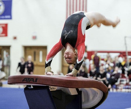 Maddie Mullenbach hits the vault during the Section 1A meet Saturday in Packer Gym. Eric Johnson/photodesk@austindailyherald.com