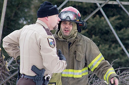 Freeborn County Sheriff Kurt Freitag talks with a Freeborn firefighter Monday afternoon at the scene of the fire.